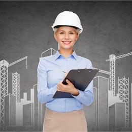 Smart dressed woman in blue shirt holding clipboard and wearing a hard hat