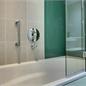 Side view of bath with chrome handle and chrome circular shower controls for shower in bath