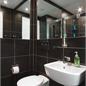 Corner View of Modern Black Tiled Bathroom Pod With Mirrors On Both Corners